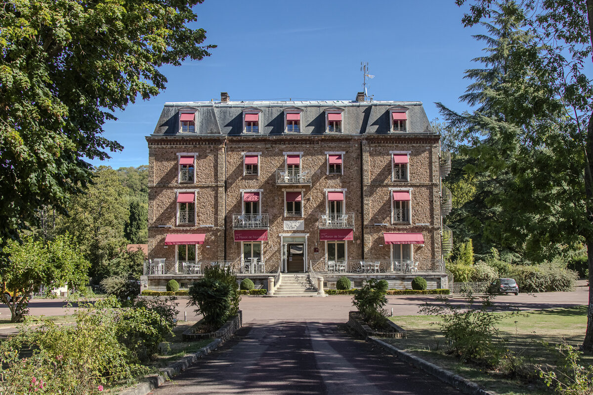Façade du Manoir de Sauvegrain au bout de l’allée, dans son parc arboré