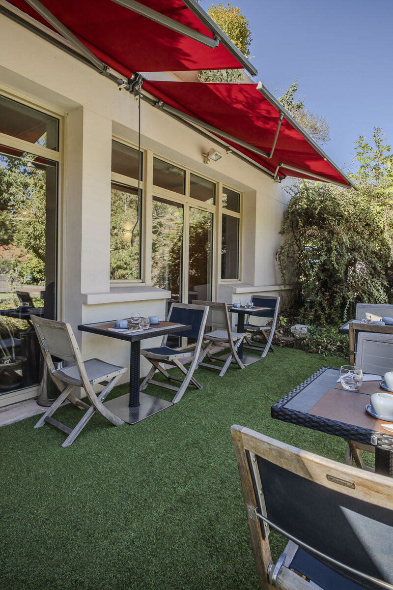 Terrasse et salon de jardin sous les stores du Manoir de Sauvegrain